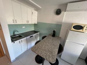a small kitchen with a table and a sink at LV Aquario I in La Pineda