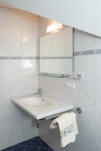 Baño blanco con lavabo y espejo en Haus Kendlinger en Sankt Gilgen