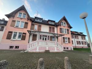 a large pink house with a lot of windows at F2 chez Cathy et Mike wittenheim in Wittenheim