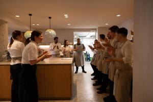 a group of people standing around a counter in a kitchen at Hotel Haus am See in Nonnenhorn
