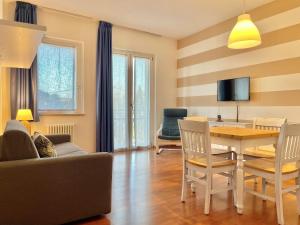 ein Wohnzimmer mit Sofa, Tisch und Stühlen in der Unterkunft Residence Beatrix in Bardolino