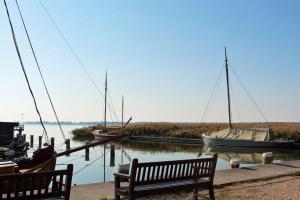 Un banco sentado junto a un muelle con barcos en el agua. en Ferienhaus " Baltic", en Wieck