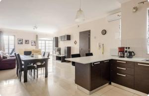 a kitchen and living room with a table and chairs at Elegant central apartment in Sliema