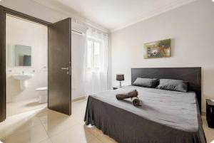 a bedroom with a large bed and a bathroom at Elegant central apartment in Sliema
