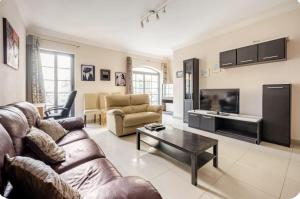 a living room with a couch and a table at Elegant central apartment in Sliema