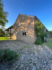 a brick building with a bench in front of it at River Cottage By Birch Stays in Glasbury
