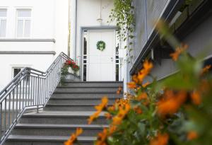 a stairway leading to a white door with a wreath at Pension Am Sültebrunnen in Bad Oeynhausen