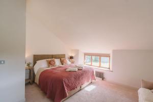 a bedroom with a bed with a red blanket at River Cottage By Birch Stays in Glasbury +35 photos