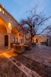 a courtyard with tables and chairs and a tree at Narlı Ev Butik Otel in Urfa