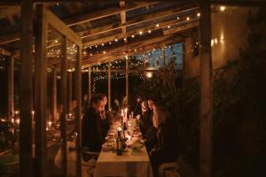 a group of people sitting at a table with lights at River Cottage By Birch Stays in Glasbury