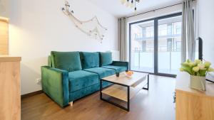 a living room with a blue couch and a table at Morzlive, Sun & Snow in Ustronie Morskie