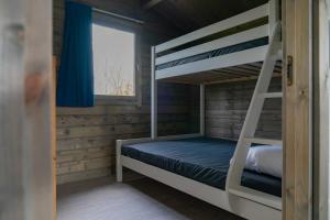 a bunk bed in a cabin with a window at Camping Sudersé in Workum