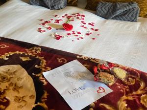 a bed with flowers on it with a piece of paper at Nature's Loft in Fouriesburg