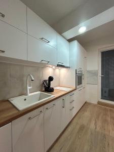 une cuisine avec des armoires blanches et un évier dans l'établissement The Studio Apartment, à Ohrid