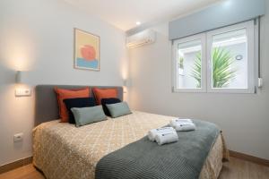 a bedroom with a bed with two towels on it at Charming Bright House w/ Garden by HostWise in Porto