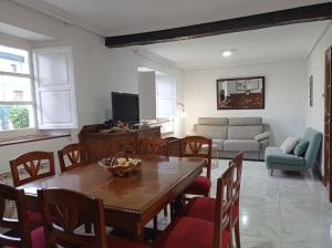 Una sala de estar con una mesa y sillas de madera. en Casa Pita, en Bárcena de Cicero