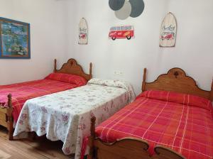 1 dormitorio con 2 camas y 1 dormitorio rojo en Casa Pita, en Bárcena de Cicero