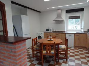cocina con mesa de madera y sillas en Casa Pita, en Bárcena de Cicero