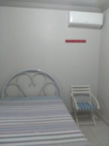 Un dormitorio con una cama y una silla azul. en Ótima Casa em Itapema SC, en Itapema