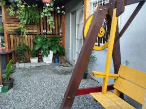 un banco de madera en un patio con una casa en Ótima Casa em Itapema SC, en Itapema