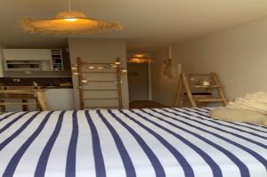 a bedroom with a blue and white striped bed at Ma Cabane de Plage in Fécamp