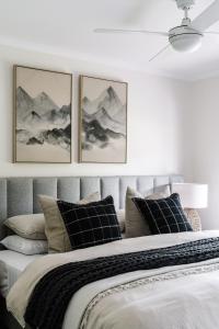 a bedroom with a bed with three pictures on the wall at Athlete's Retreat - 21A Service Street in Porepunkah
