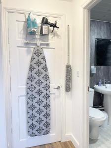 a bathroom with a door with a tie on it at Norwich 1st Floor Apartment in Goodmayes