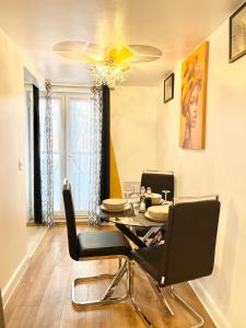 a dining room with a table and black chairs at Norwich 1st Floor Apartment in Goodmayes