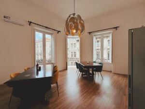 Un comedor con una mesa y sillas y una lámpara de araña. en Candalù - Palermo Suite, en Palermo