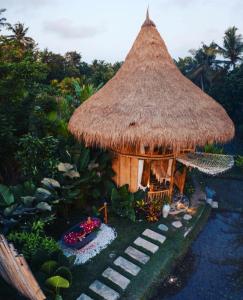 a small hut with a grass roof and stairs at DD Bamboo Lodge in Gianyar