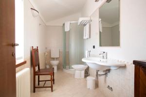 a bathroom with a sink and a toilet and a mirror at Agriturismo Tonutti in Tavagnacco +37 photos