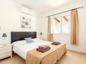 a bedroom with two beds with towels on top of them at Villa Valeria in Cala'n Porter +16 photos