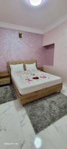 Una cama en un dormitorio con una pared rosa. en Safi vacances, en Zri Ouled 10 fotos más