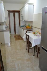 a kitchen with a table and chairs and a kitchen with white cabinets at B&B Visconti in Lido di Ostia