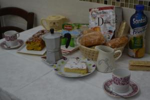 a table with cups and plates of food and bread at B&B Visconti in Lido di Ostia