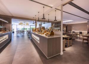 a restaurant with a bar with tables and chairs at INNSiDE by Meliá Barcelona Aeropuerto in El Prat de Llobregat