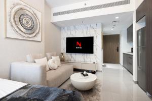 a living room with a couch and a tv at شقة استوديو فاخرة في الزاهية الشارقة - cozy Studio in Sharjah