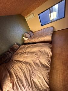 a bedroom with a bed and a window at Sin-imamiya House in Osaka