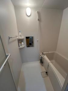 a white bathroom with a tub and a sink at Sin-imamiya House in Osaka +22 photos