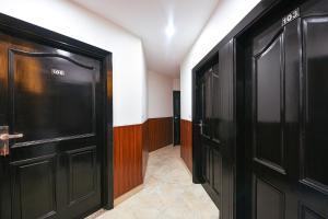 - un couloir avec deux portes noires dans une chambre dans l'établissement FabHotel The Heritage, à New Delhi