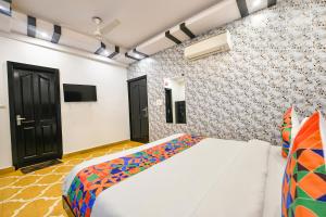 une chambre avec un lit et une télévision sur un mur dans l'établissement FabHotel The Heritage, à New Delhi