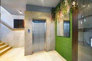 un couloir avec une porte et un mur végétal dans l'établissement FabHotel The Heritage, à New Delhi 24 autres photos
