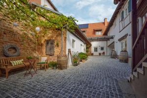 a courtyard with benches and a brick building at Winzerlodge, Wohnung Merlot in Gleiszellen-Gleishorbach +11 photos