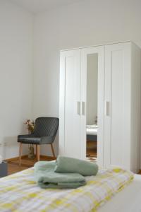 a bedroom with a bed with a cabinet and a chair at Schwarzwald Lahr Europapark Penthouse Sunshine in Lahr