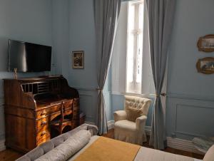a living room with a tv and a couch and a chair at Casa do Vereador in Ponta Delgada