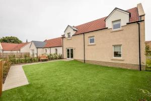 une image d'une maison avec une pelouse dans l'établissement Village Green - Kingsbarns, à Kingsbarns