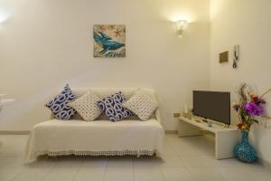 a room with a bed with pillows and a tv at Villetta Grecale Porto Cesareo in Porto Cesareo