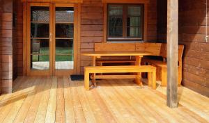 a wooden table and bench on the porch of a cabin at Ferienhaus Donau 31 Glückskäfer in Hayingen