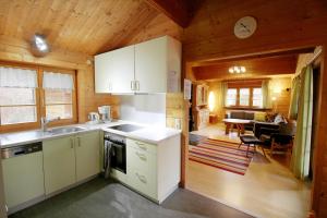 a kitchen with white cabinets and a dining room at Ferienhaus Donau 31 Glückskäfer in Hayingen