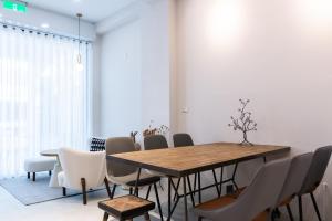 a dining room with a wooden table and chairs at 暮夏包棟民宿4-16人 -新成屋-電梯-烤肉-預訂完成後務必聯繫再度確認 in Tainan